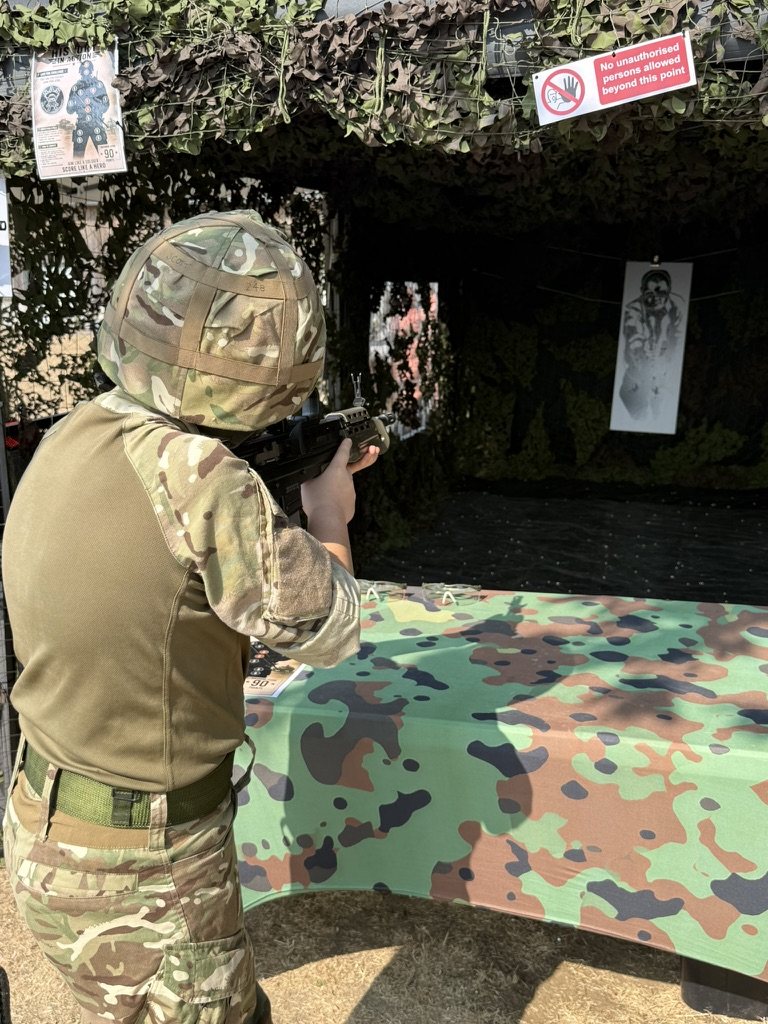 A young shooter in a helmet aiming down the enclosed lane