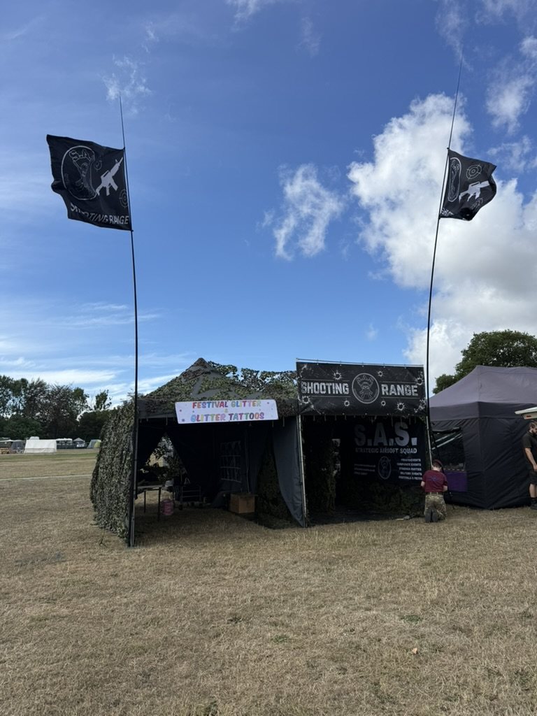 The S.A.S. range pitched in a show field with flags flying against a blue sky